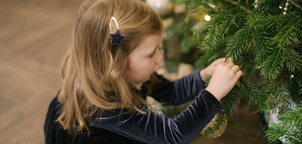 girl decorating a christmas tree