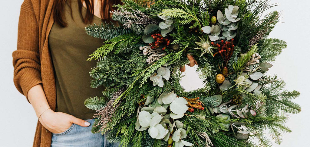 woman holding a christmas wreath