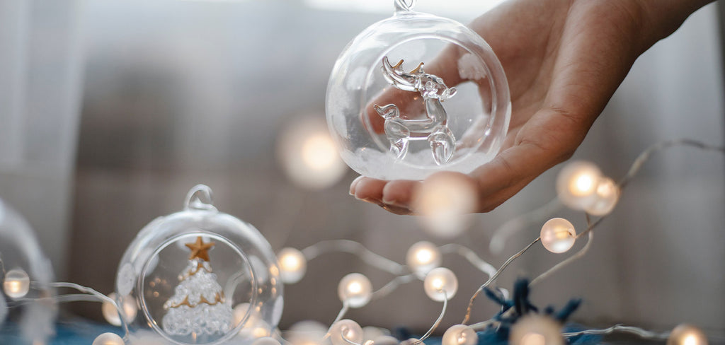 woman holding a clear christmas bauble