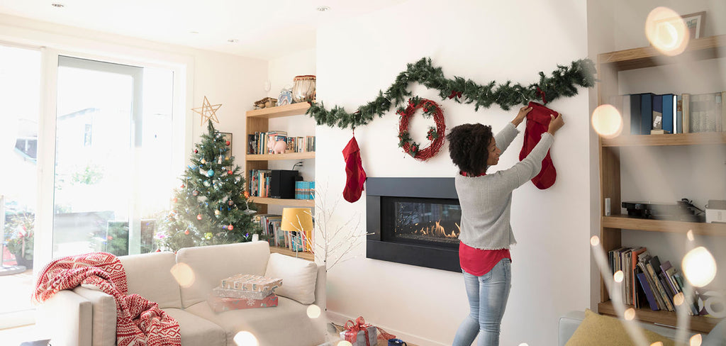 woman hanging red sock in fireplace