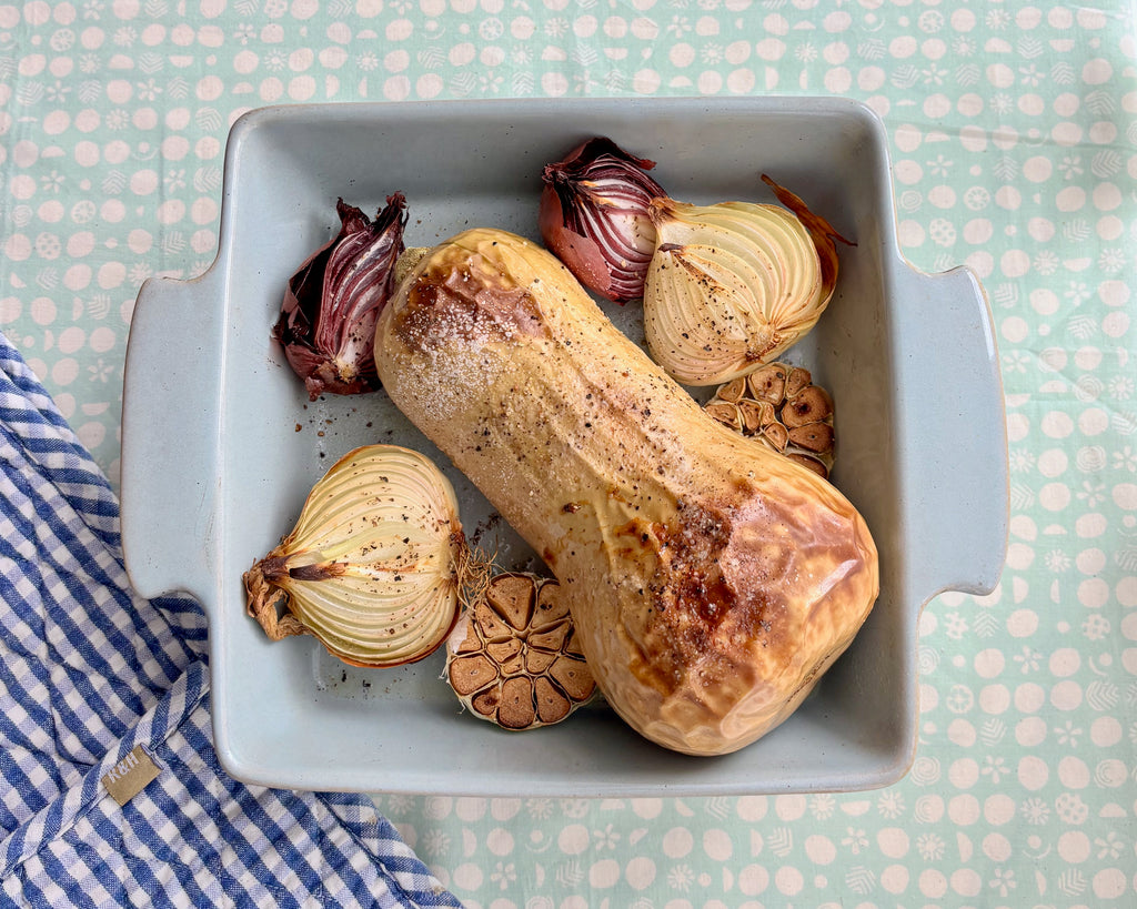 roasted pumpkin and vegetables on table with oven mitt