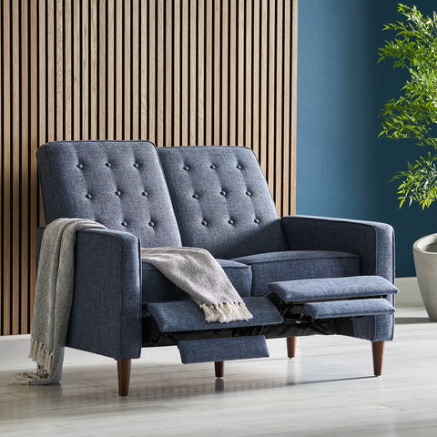 Manville Button Tufted Loveseat Pushback Recliner in front of a slat panel background with a blanket draped over the armrest