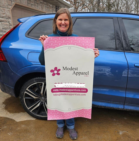 Annette Rivers, pictured with the Modest Apparel USA banner