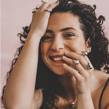 Woman wearing bird skull silver rings smiling