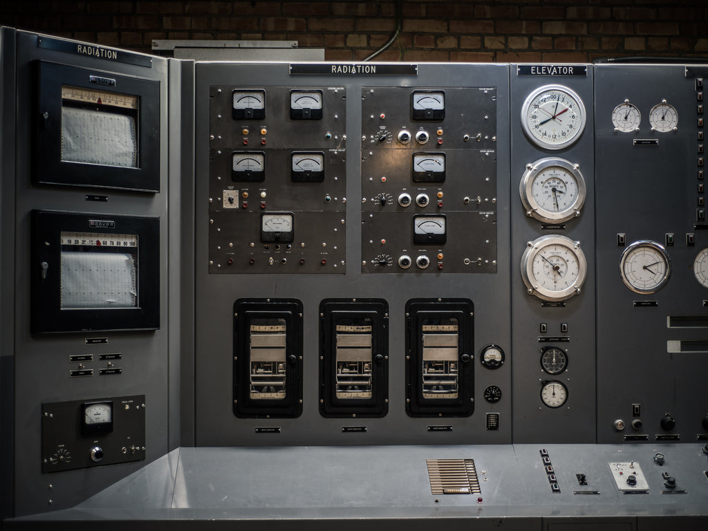 A radiation terminal with lots of buttons, meters, and clocks.