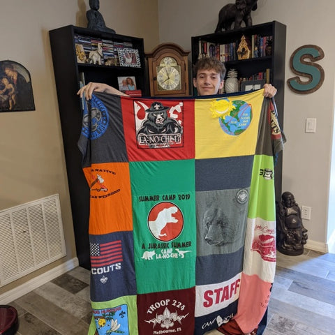 Cary S.’s son holding up his Custom MemoryStitch T-Shirt Quilt