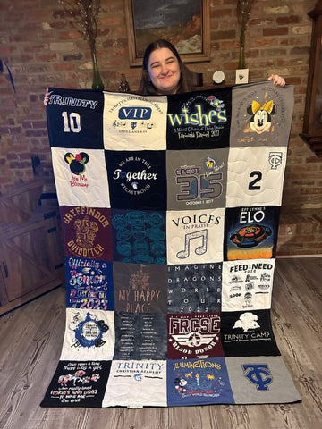 Christina D.’s daughter happily holding up her MemoryStitch T-Shirt Quilt