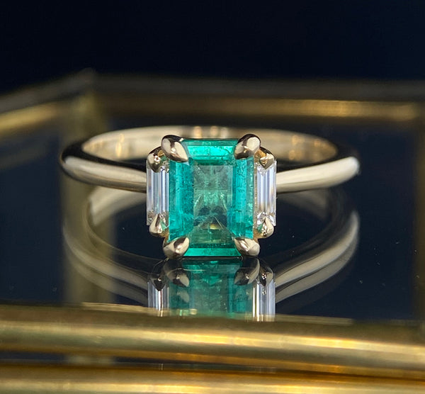 Emerald Cuts with pointed claws over the corners are an elegant and safe type of setting to showcase this Brazilian emerald with lab diamond baguette accents