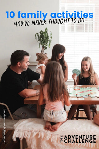 A family sitting around a table while bonding over board games; image overlaid with text that reads 10 Family Activities You've Never Thought to Do
