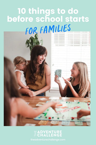 Mother carrying her little toddler while sitting at a table with her two daughters playing monopoly; image overlaid with text that reads 10 Things to Do Before School Starts (For Families)