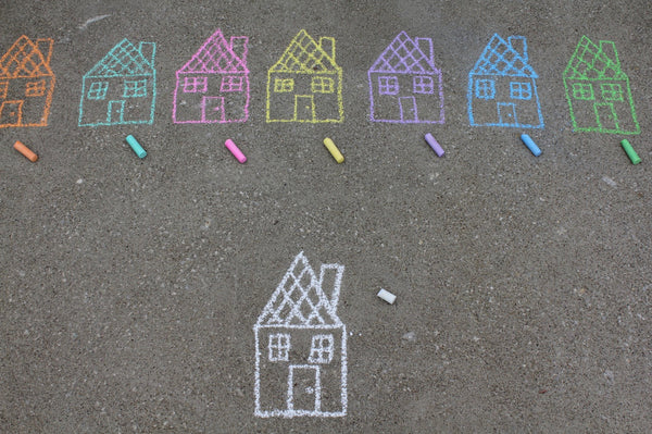 Chalk sketches of houses using different colored chalks on the sidewalk