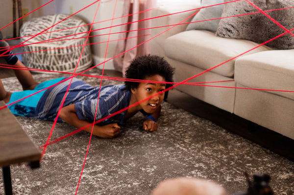 Little boy going through their makeshift obstacle course in the living room