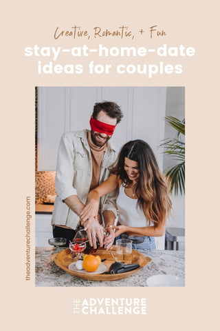 Couple playing a game during their date with the guy wearing blindfold; image overlaid with text that reads Creative, Romantic, and Fun Stay-at-Home Date Ideas for Couples