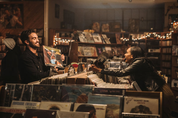 5 date ideas to celebrate national couple’s day: Couple sharing laughs as they hang out at record store.