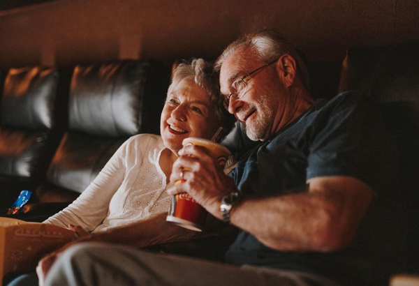 55 Cheap Date Ideas That Are Fun And Create Connection. Elderly couple smiling as they watch a movie together at the cinema.