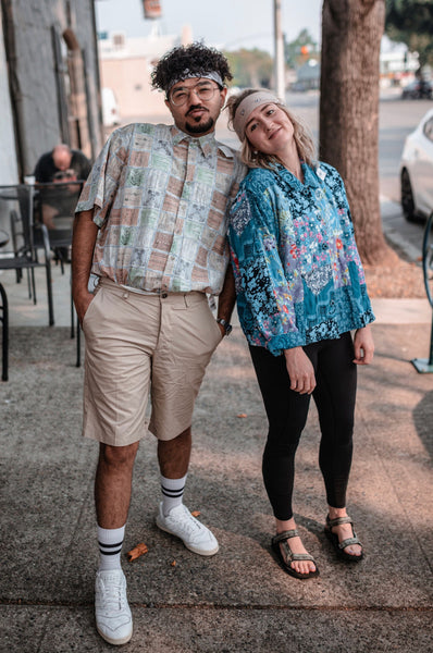 55 Cheap Date Ideas That Are Fun And Create Connection. Couple pose with each other as they wear clothes that they thrifted together.