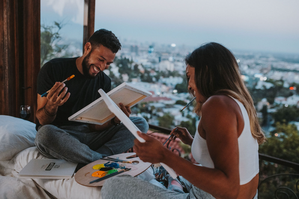 55 Cheap Date Ideas That Are Fun And Create Connection. Couple sharing laughs as they paint together.