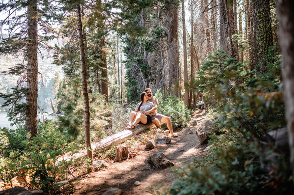 55 Cheap Date Ideas That Are Fun And Create Connection. Couple sitting together on a log during their nature hike.