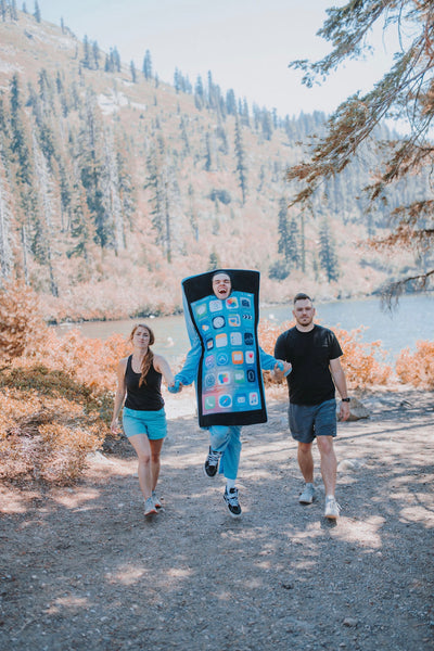 Image of a couple holding hands with a guy wearing an iPhone costume.