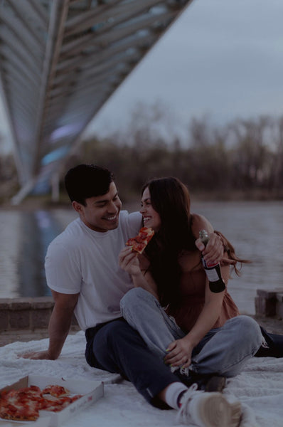 7 Ways to Rekindle Your Relationship's Spark: Couple on date by the river and eating pizza