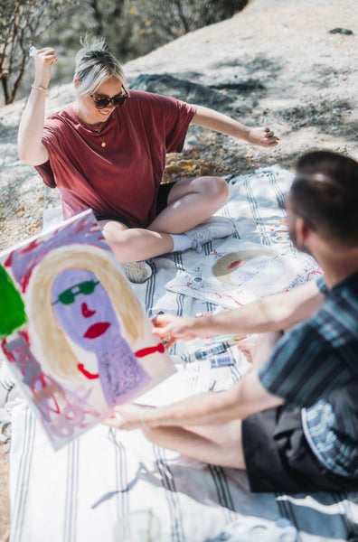 7 Ways to Rekindle Your Relationship's Spark: Couple painting each other by the lake