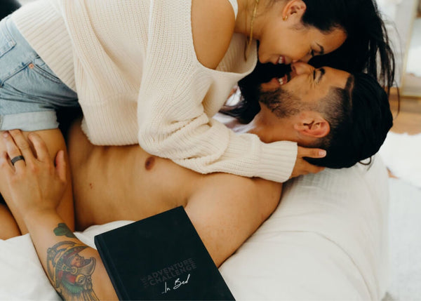 At Home Date Night Ideas: Couple doing a challenge from The Adventure Challenge ‘...In Bed’ Book