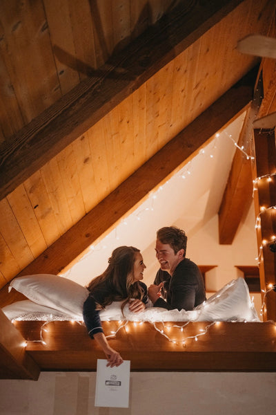 Bedroom Decoration Ideas to Make Your Anniversary More Romantic: Couple with twinkle lights around them.