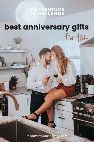 Couple enjoying a glass of wine in their own kitchen; image overlaid with text that reads Best Anniversary Gifts for Him