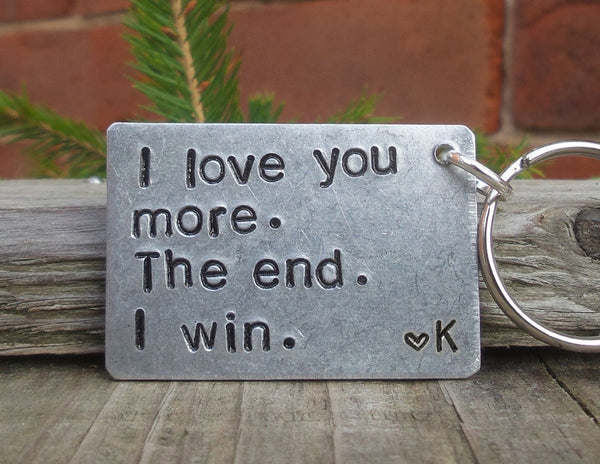 A playful keyring with text that reads ‘I love you more. The end. I win.'