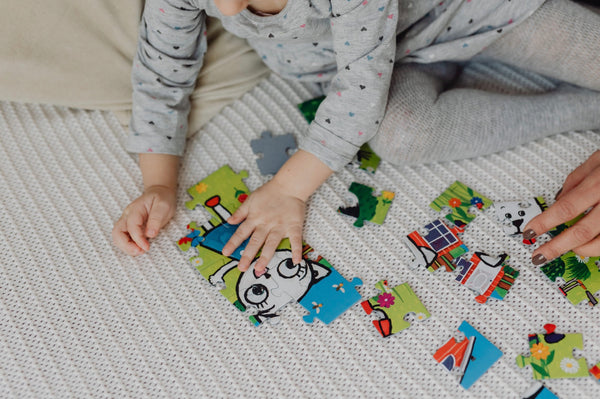 Close-up shot of little boy playing with puzzles before bedtime, a suggestion from The Adventure Challenge