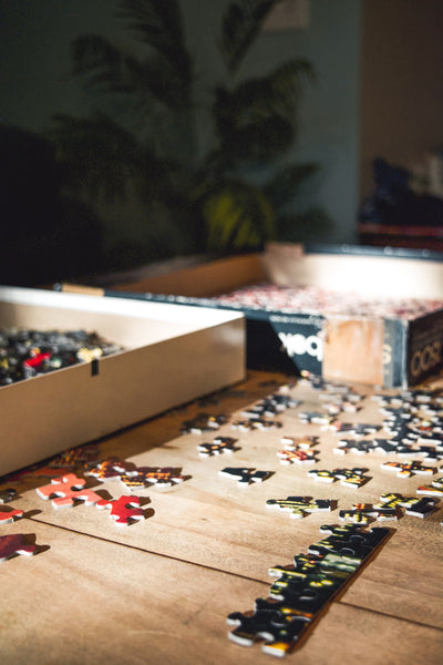  Cheap Date Ideas (That Don't Feel Cheap). Close-up photo of scattered puzzle pieces on a wooden table.