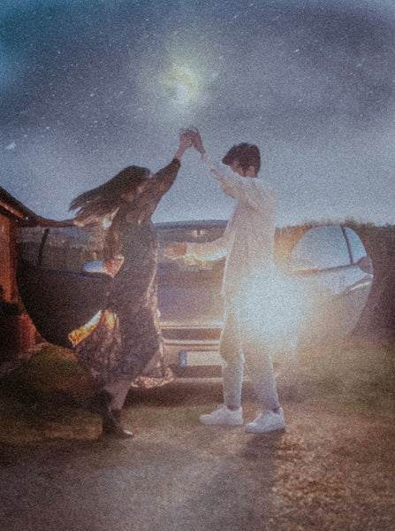  Cheap Date Ideas (That Don't Feel Cheap). Couple dances under the stars with their car behind them.