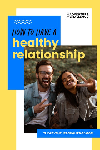 A couple smiles together while sitting on a picnic blanket and making peace signs; image overlaid with text that reads how to have a healthy relationship