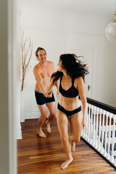 How to Last Longer in Bed with Your Loved One: Couple playing chase down the hall in their underwear.