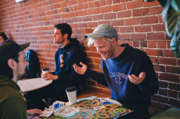 A man smiles while playing a board game with friends.