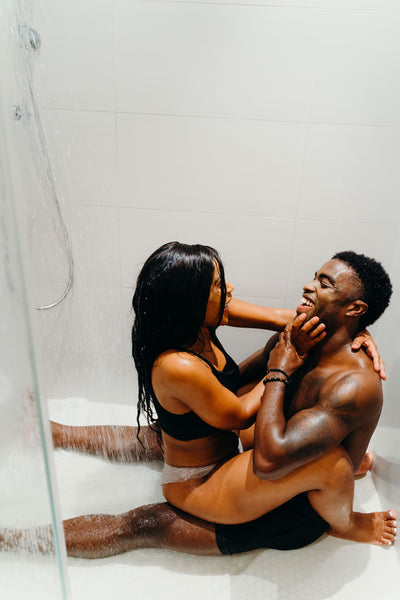 How To Spice Things Up In The Bedroom: Couple sharing laughs while on the floor in the shower