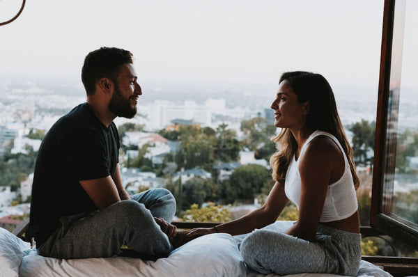 How To Spice Things Up In The Bedroom: Couple talking by the window and looking intensely at each other