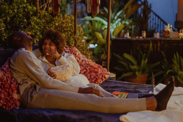 How To Spice Things Up In The Bedroom: Couple sharing a conversation and eating popcorn