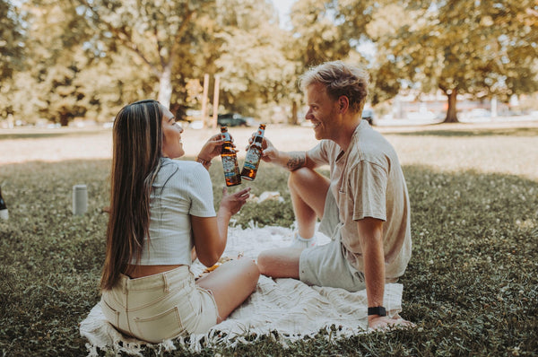 93 Best Conversation Starters for Couples to Better Connect: Couple sharing a toast over an outdoor picnic.