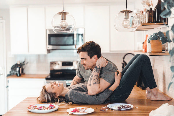 The Adventure Challenge: Woman lying on the kitchen counter with her boyfriend leaning on top of her.
