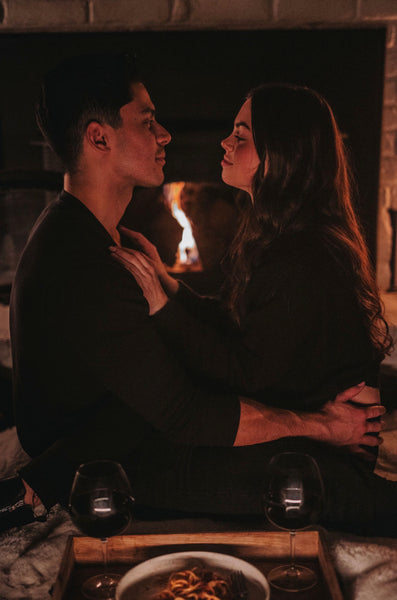 Couple sharing an intimate embrace as they voice out their needs while facing each other in front of a fireplace