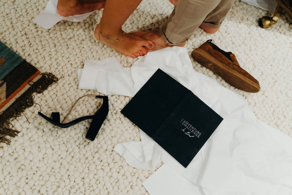 Flat-lay shot of Adventure Challenge in Bed book with couple's shoes messily thrown on the floor