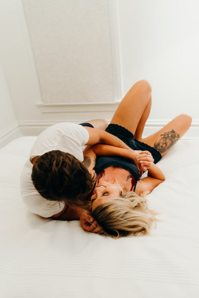 The 15 Best Sex Games for Couples to Spice Up the Romance: Couple cuddling and hugging in bed