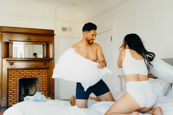 The 15 Best Sex Games for Couples to Spice Up the Romance: Couple in bed pillow fighting 