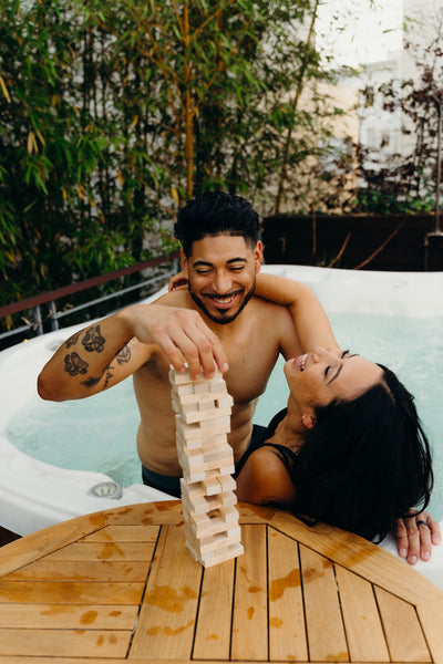 The 15 Best Sex Games for Couples to Spice Up the Romance: Couple in hot tub playing Jenga