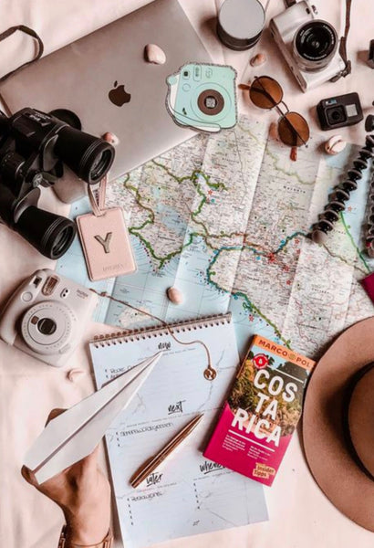 An image of maps and various travel items laid out on a table.