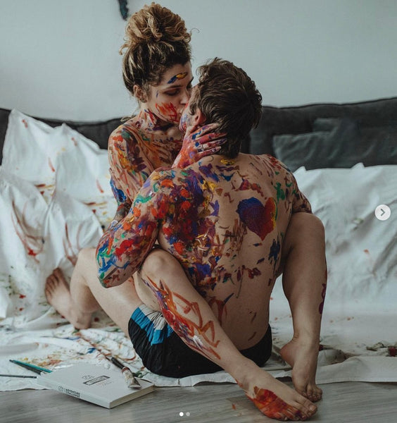 Why You Should Have a Sexual Bucket List: Couple sharing a kiss on the floor with body paint on them.
