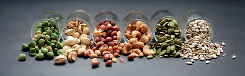 Mix Nuts in the glass on black background close up , peanut peas sunflower seeds pumpkin seeds cashew nuts pistachios