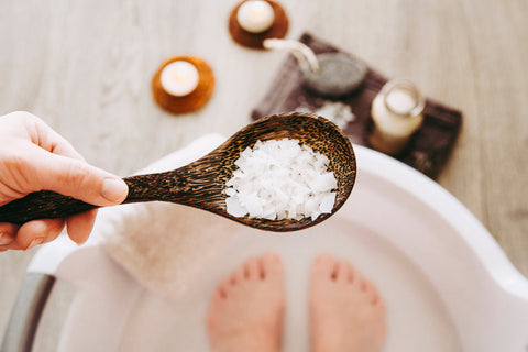 Adding Magnesium Chloride vitamin salt in foot bath water, solution. Magnesium grains in foot bath water are ideal for replenishing the body with this essential mineral, promoting overall well being.