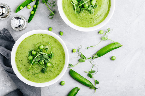 Summer cream soup with green fresh pea shoots. Top view